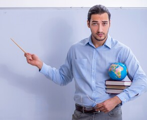 Canvas Print - Young male geography teacher in front of whiteboard