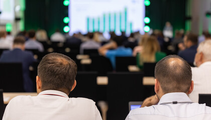 Wall Mural - rear view of the audience at a business conference meeting event listening to the speakers speech