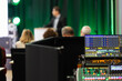 © leszekglasner - Sound engineer backstage with audio equipment during corporate conference speaker giving a talk