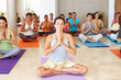 © Leffy/peopleimages.com - People, personal trainer and meditation with yoga class for zen or awareness together in dojo. Young, team or yogi on mat for spiritual wellness, inner peace or balance in relax, fitness or exercise