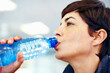 © STEEXBuyout/peopleimages.com - Fitness, sweat or woman drinking water for health, wellness or nutrition with face profile in gym. Tired, liquid or thirsty athlete with bottle for hydration on break after exercise, sport or workout