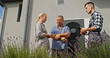 © StockMediaSeller - A technician discusses heat pump maintenance with homeowners in a garden, near the external unit.
