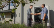 © StockMediaSeller - A technician and a homeowner shake hands beside an external heat pump, concluding a service visit.