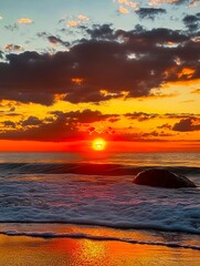 Poster - A sunset over the ocean with a rock in the foreground