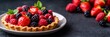 © Sanwa - A close-up shot of a delicious mini pie topped with fresh strawberries, raspberries, and blackberries on a white plate, with a black background. This image is perfect for showcasing your bakery's dele