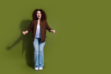 Full size photo of pretty young woman raise fists empty space isolated on khaki color background