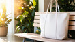 © Anuyj - White tote bag on a wooden chair in a garden setting.