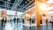 © TensorSpark - Dynamic business expo with a lively trade show floor, blurred background showcasing booths, attendees, and vibrant lighting.