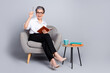 © deagreez - Full size photo of nice retired female sit armchair write notebook eureka wear trendy formalwear outfit isolated on gray color background