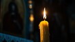 © Elena - A single candle, lit in front of an icon of the revered Saint Mary and Theotokos, concept of orthodox holidays, prayer, religious sacrament, God's help, prayer to the Virgin Mary