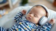 © Pinklife - The baby is lying down wearing large headphones and cozy striped pajamas with nautical patterns, seeming to enjoy the audio experience in a peaceful room setting.