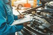 © VICHIZH - Mechanic inspecting a car engine with a checklist in hand, focused on maintenance tasks in an auto repair workshop