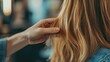 © Suphawan - A hairdresser showing a client split ends during a consultation, emphasizing the need for a trim.