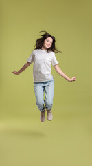 Poster - Cute teenage girl jumping on olive background