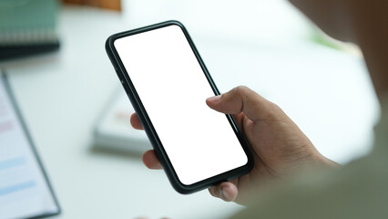 Wall Mural - close up shot of man holding a smartphone with a blank white screen, for mockups or showcasing mobil