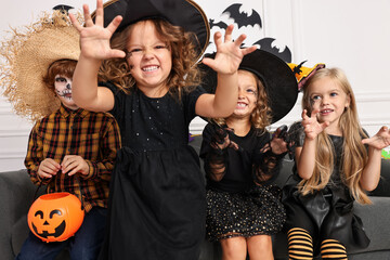 Sticker - Cute children with pumpkin bucket wearing costumes indoors. Halloween celebration