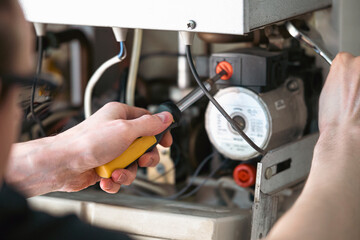 A man is repairing a water-heating boiler.