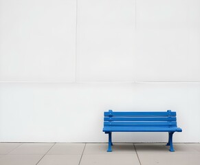 Wall Mural - A blue park bench on a paved surface against a plain white wall.