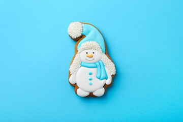 Wall Mural - Tasty Christmas cookie in shape of snowman on light blue background, top view