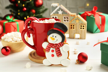 Sticker - Delicious cookie in shape of snowman, cup with cocoa and Christmas decor on white wooden table