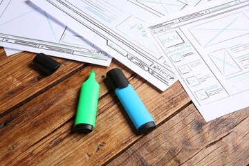 Wall Mural - developing ui design. sketches of website wireframes and felt pens on wooden table, closeup