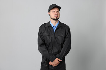 Wall Mural - Security guard in uniform with earpiece on grey background