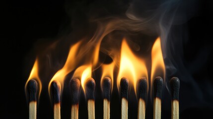 Eight matches burning with smoke on black background.