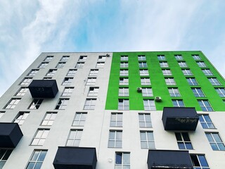 Low angle perspective High-rise rectangular Residential building against the blue sky. Modern architecture. Detail New high rise House facade with windows. Real Estate business concept.