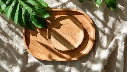 Wall Mural - Elegant flat lay of a wooden tray resting on a linen tablecloth adorned with delicate green leaf shadows