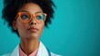 © JoxyAimages - Thoughtful woman wearing orange glasses in a medical setting, exemplifying professionalism and introspection within the backdrop of a healthcare environment.