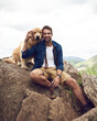 © JordaanExams/peopleimages.com - Man, happy and dog in nature for travel, hiking and holiday with bonding, connection and portrait. Male person, face and golden retriever outdoor for pet care, vacation or break on weekend with puppy