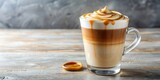 Delicious caramel macchiato in a clear glass with swirls of caramel drizzle