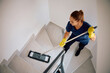 © Drazen - Above view of housekeeper cleaning  stairs with  mop.