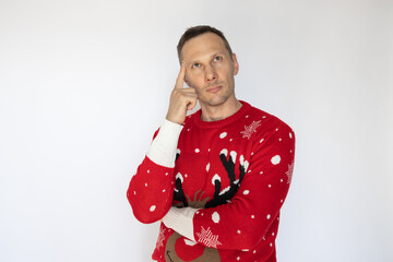 Young Caucasian man with red sweater celebrating the Christmas holidays standing and thinking an idea on white background