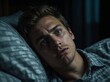 © theartofphoto - Young man Mark wakes up suddenly in the dark, surprised and alert while lying on his pillow in a dimly lit room. Generative AI