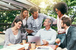 © JordaanExams/peopleimages.com - Cafe, business people and laptop with tablet for discussion, research and planning for creative startup. Career, collaboration and design team with digital for social media page, website and review