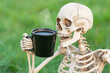 © Vilma - skeleton drinking a black cup of coffee, funny realistic Halloween concept
