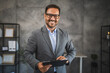 © Miljan Živković - Portrait of confident businessman smile at office and hold clipboard