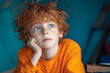 © ChaoticDesignStudio - A thoughtful young boy with curly red hair gazes upward while resting his chin on his hand