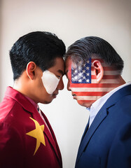 Two men face to face with flags of USA and China painted on their faces