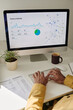 © pressmaster - Image shows person analyzing visitors activity data on large computer screen with charts and graphs, coffee mug, and plant on desk
