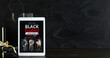 © Pixel-Shot - Tablet computer with Black Friday fashion sale advertisement, gift boxes and shopping bag on dark grunge background