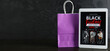 © Pixel-Shot - Tablet computer with Black Friday fashion sale advertisement and shopping bag on dark wooden table