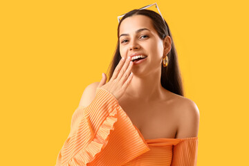 Poster - Surprised young woman on yellow background