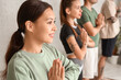 © Pixel-Shot - Sporty young woman meditating in gym, closeup