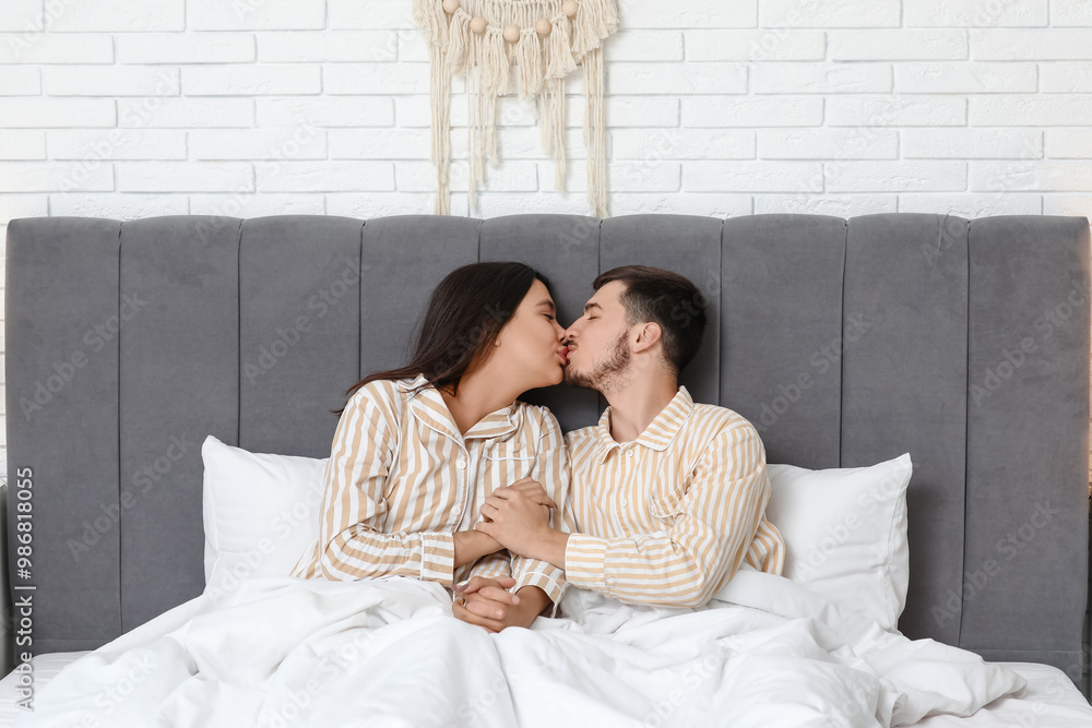 Young couple kissing in bed at home