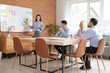 © Pixel-Shot - Young Asian woman working on business plan near whiteboard with her colleagues in office