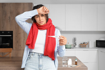 Canvas Print - Sick African-American woman measuring temperature at home