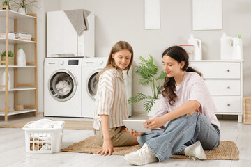 Canvas Print - Female students using tablet computer in dorm laundry room