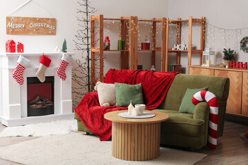 Poster - Interior of living room with green sofa, fireplace, Christmas tree and festive decorations